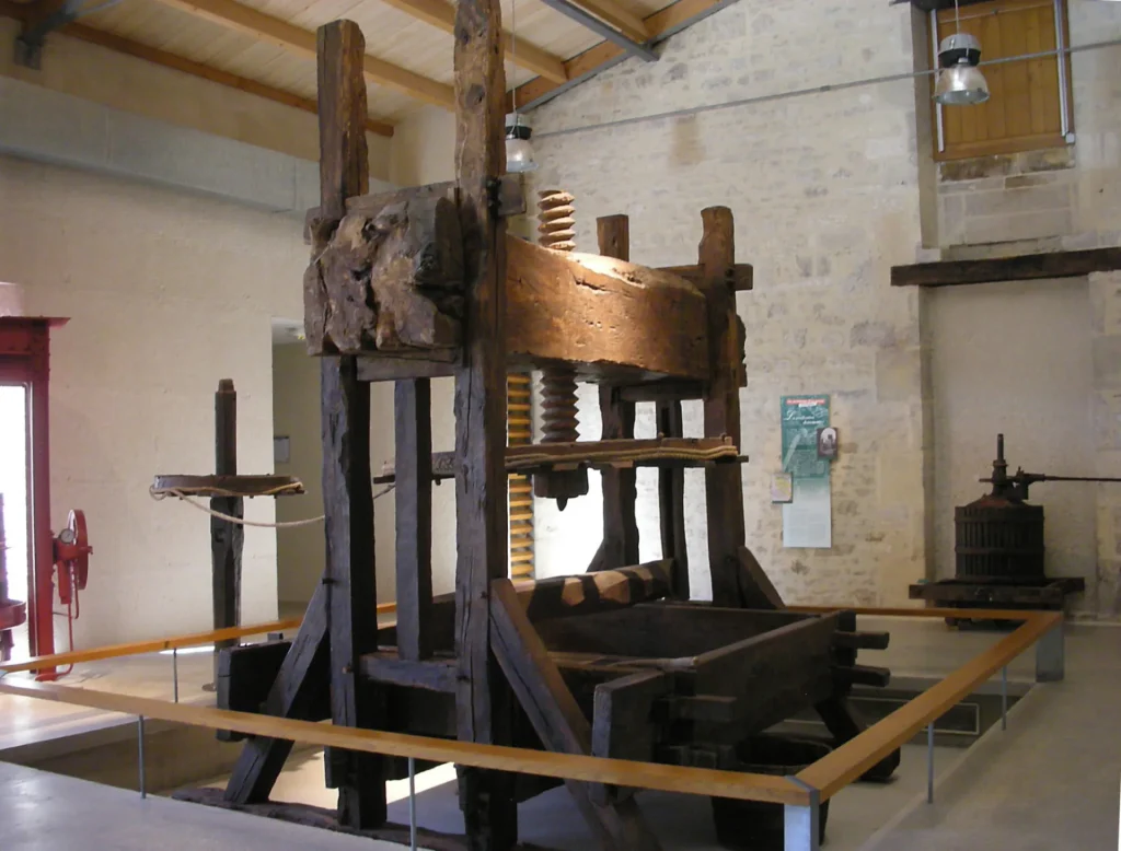 Old wooden press used to press grapes in the Cognac vineyards, on display at the Musée des savoir-faire du cognac in Cognac.