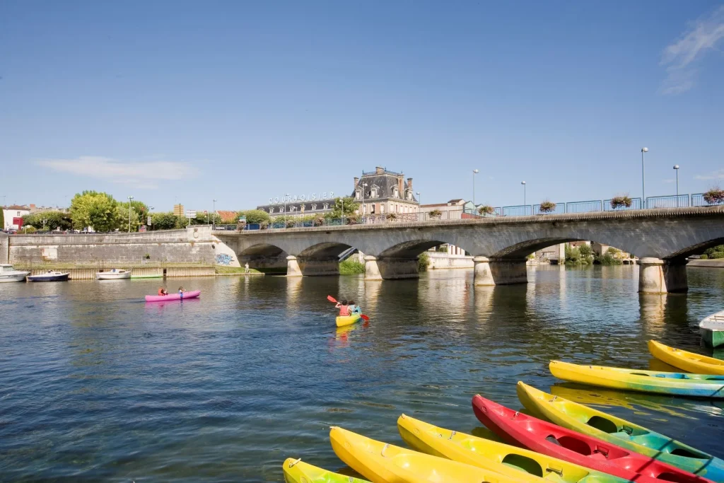 Le fleuve charente à jarnac, au premier pla des canoës du jarnac canoe kayak club , au second plan le pont reliant gondeville à jarnac, en arrière plan la maison de cognac courvoisier