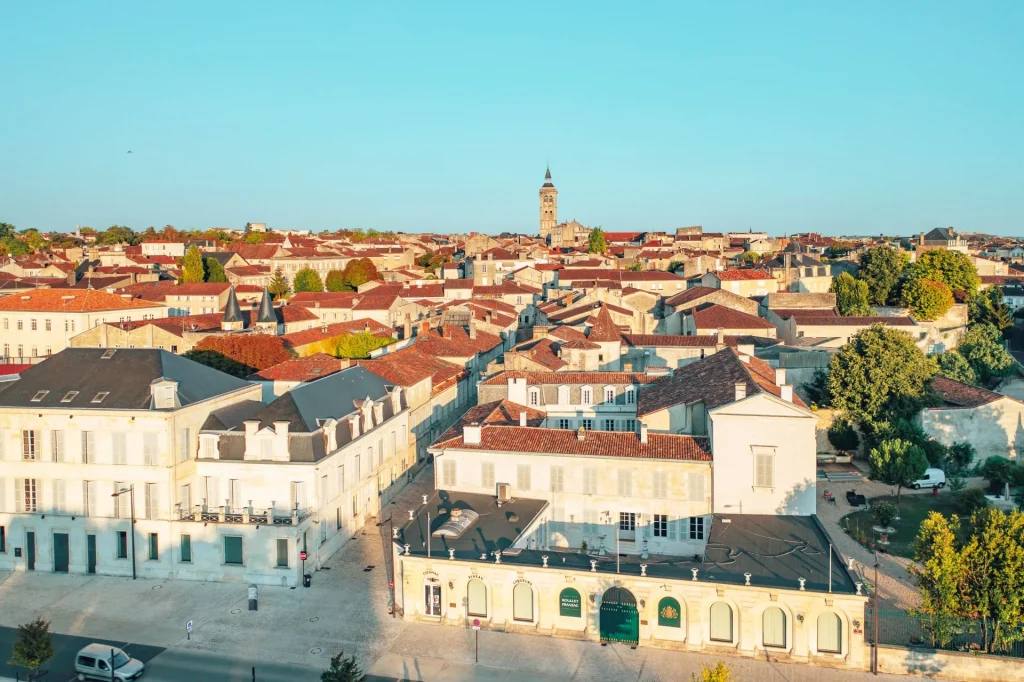 Aerial view of the old town of Cognac, with the quays of the Charente and rue Saulnier in the foreground and the bell tower of Saint Léger church in the background in summer