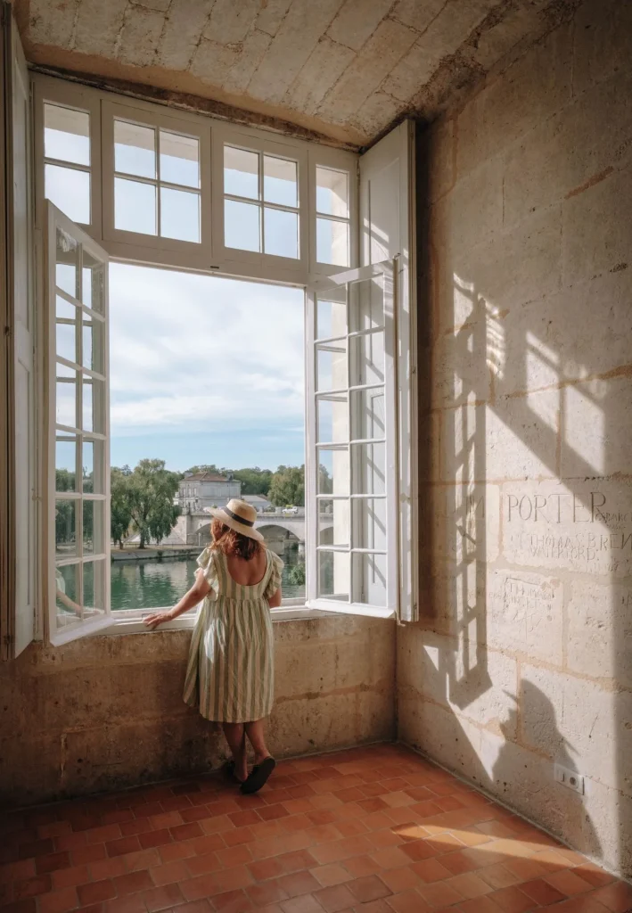 A woman admiring the view of the Charente and the Pont Neuf from the Château de Cognac (baron Otard cognac), old graffiti