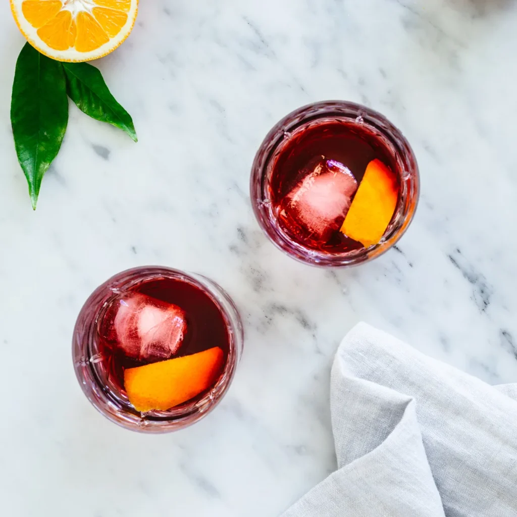 Glasses of red Pineau des Charentes on the rocks with orange zest