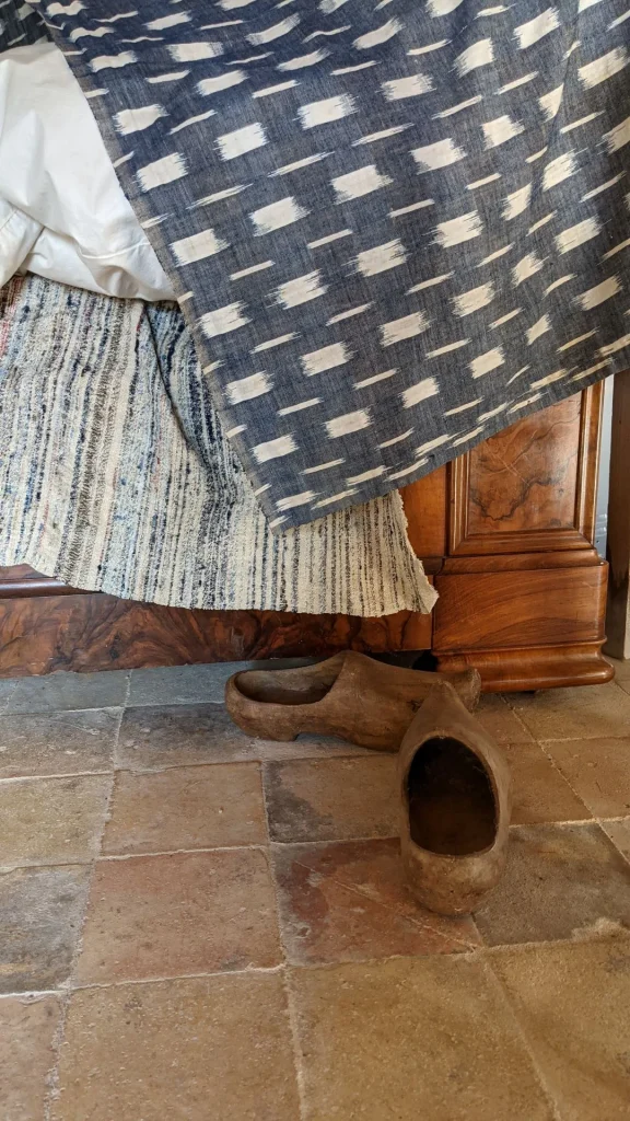 la petite maison du lin à Lignières Ambleville, pièce à vivre du tisserand, les sabots en bois au pied du lit