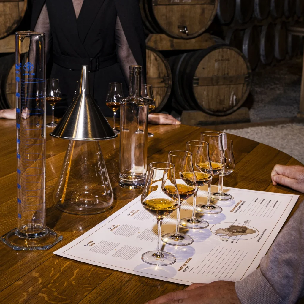 Atelier maître assembleur, assemblage d'eaux-de-vie de la maison de négoce Camus à Cognac, verre de cognac dans un chai de vieillissement