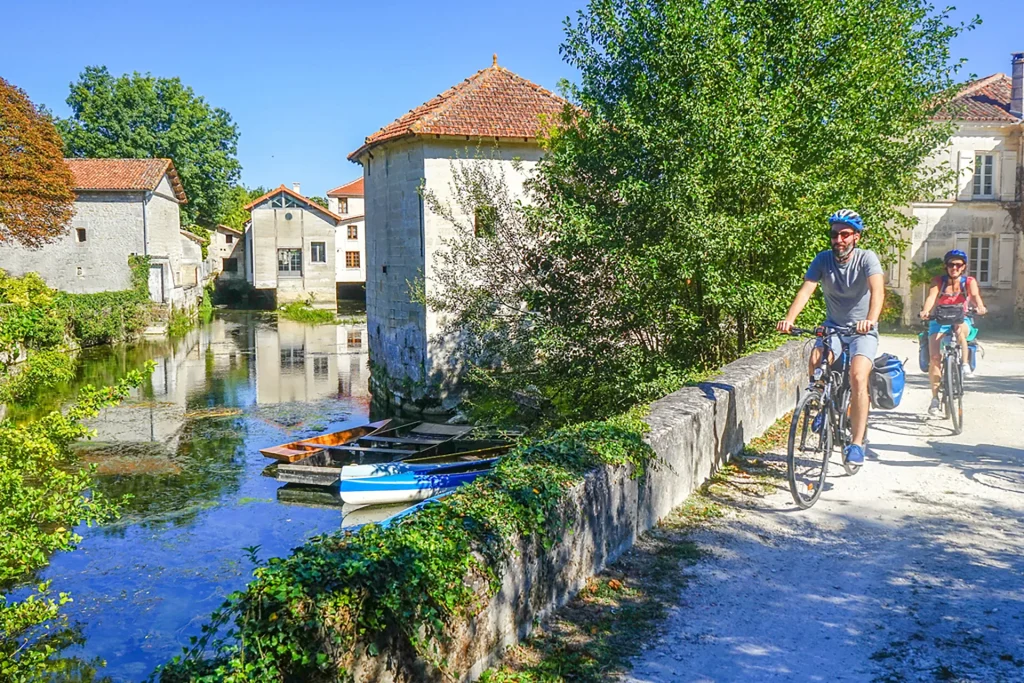 The Flow Vélo cycle route along the Charente in Cognac, passing through St-Simeux, cyclists on the banks of the Charente at Les Essacs in St-Simeux.
