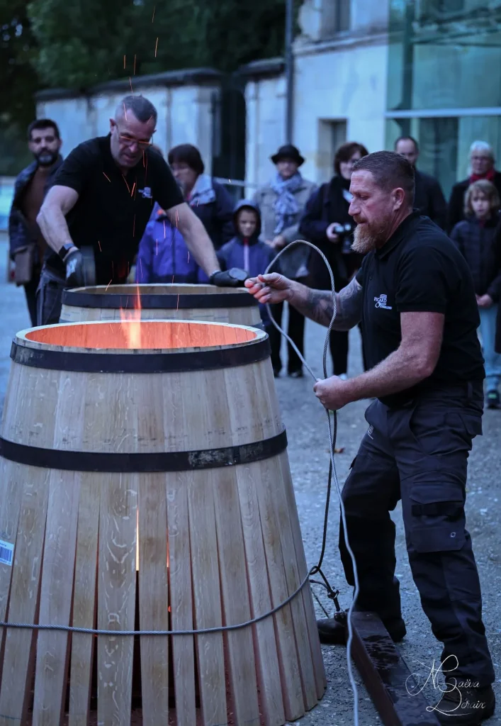 démonstration de tonnellerie avec deux tonneliers de la tonnellerie Vicard façonnant chacun une barrique devant le musée des savoir-faire du cognac