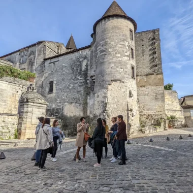 Guided tour of Cognac from the Middle Ages to the present day with a group of people led by Nath, a guide from the Destination Cognac Tourist Office, through the cobbled streets of the old town of Cognac, behind the royal castle of Cognac and the François 1er fountain.