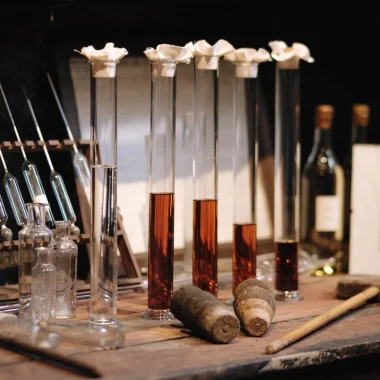 Éprouvettes remplies d'eau-de-vie de cognac et alcoomètres dans un chai de vieillissement à Segonzac