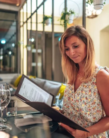 Jeune femme qui lit la carte d'un restaurant à Cognac