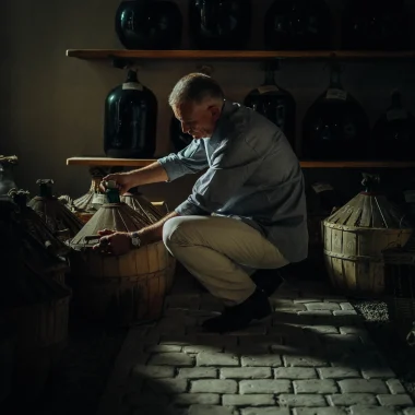 Maitre de chai de la maison de négoce Bache Gabrielsen vérifiant une dame-jeanne dans laquelle est conservé le cognac à Cognac